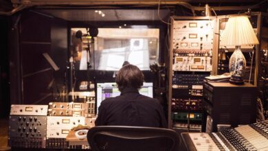 Pria di depan mixer dan penerima studio